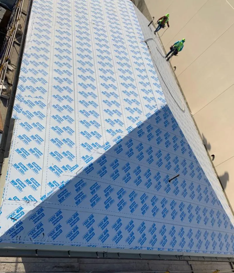 Professional roofers installing underlayment on a metal roof in Newmarket